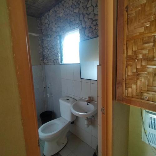 a small bathroom with a toilet and a sink at Palaboy Skatecamp Native House Beach Resort in Daanbantayan