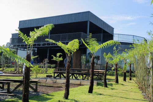 a building with benches and trees in front of it at Healing Space Bungallow Bao Loc in Bao Loc