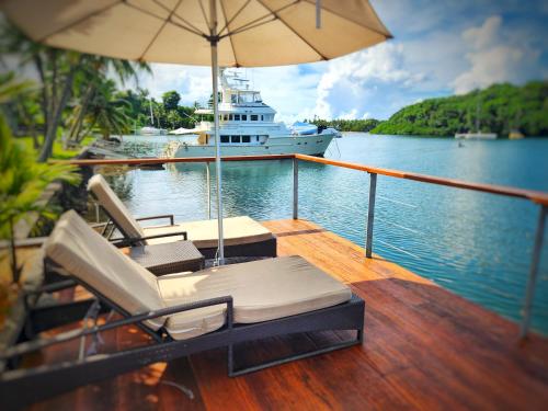 a boat with chairs and an umbrella on the water at Novotel Suva Lami Bay in Suva