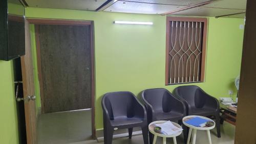 a waiting room with three chairs and a table at Balaji property in kolkata