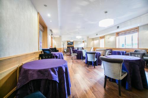 a dining room with purple tables and chairs at The Pillar Hotel in London