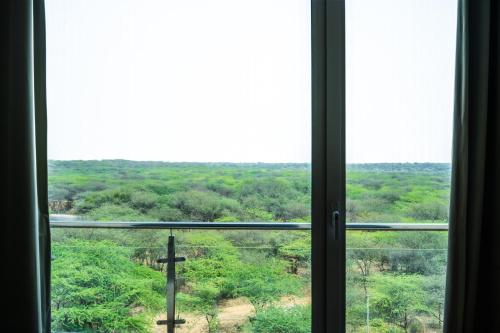 a window with a view of a cross on a field at Eternal Oasis by Alaya Stays, Golf Course Road in Gurgaon