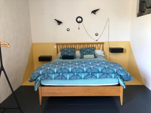 - une chambre dotée d'un lit avec une horloge murale dans l'établissement La Distillerie, à Couffoulens