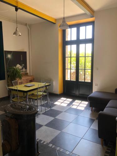 un salon avec une table et un canapé dans l'établissement La Distillerie, à Couffoulens