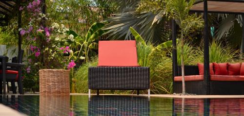 a couple of chairs sitting next to a pool at Eureka Villas Siem Reap in Siem Reap