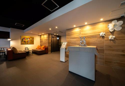 a lobby with a flower vase on a wall at WELLSTAY Osaka Shinimamiya Station in Osaka