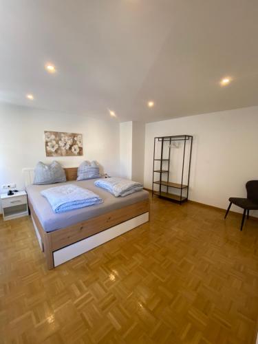 a bedroom with a bed and a wooden floor at Ferienwohnung Scheuring 1 OG links in Nordheim