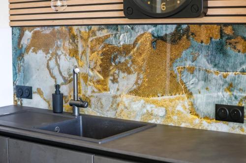 - un comptoir de cuisine avec évier et une horloge murale dans l'établissement Maison du bonheur #Haut de Gamme, à Cognac