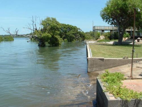 a body of water with trees and a bridge in the background at Russ Vegas in Russell Island