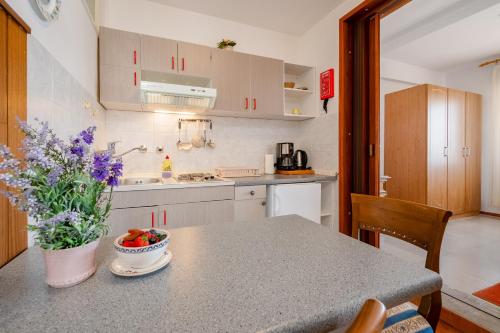 a kitchen with a table with a bowl of fruit on it at Villa Segetski dvori - Tradition since 1964 in Trogir