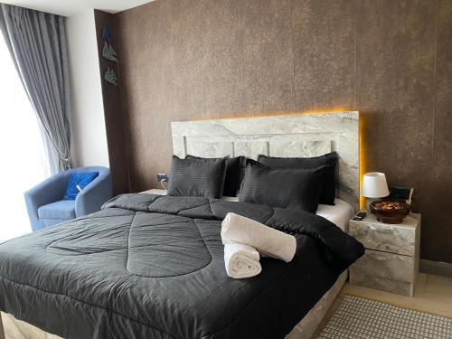 a bedroom with a large bed and a blue chair at Luxury one bedroom in Diamond in the city in Accra
