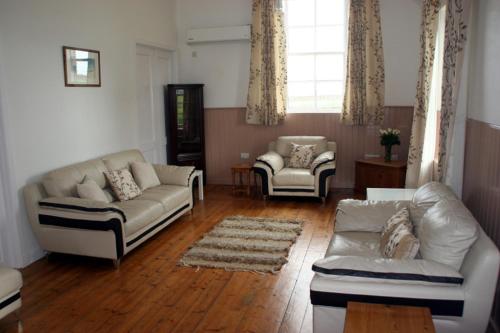 uma sala de estar com dois sofás e duas cadeiras em The Reid Hall em Pierowall