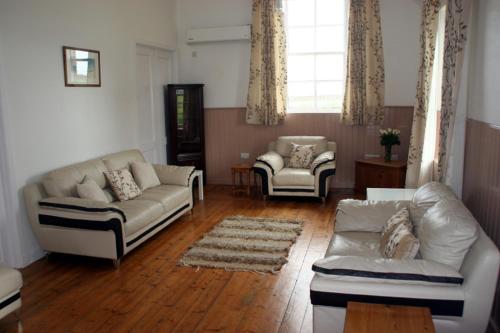 a living room with two couches and two chairs at The Reid Hall in Pierowall