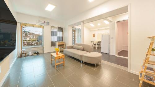 a living room with a couch and a table at Sokcho Seohyeon Ine Pension in Sokcho