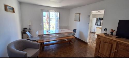 - un salon avec une table en bois et une chaise dans l'établissement Villa Berckarosse, à Berck-sur-Mer