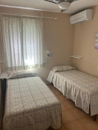 a room with two beds and a window at Butibamba in La Cala de Mijas