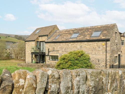 a stone house with a stone fence in front of it at The Old Telephone Exchange in Huddersfield
