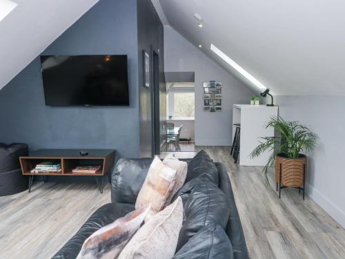 a living room with a couch and a tv at The Old Telephone Exchange in Huddersfield