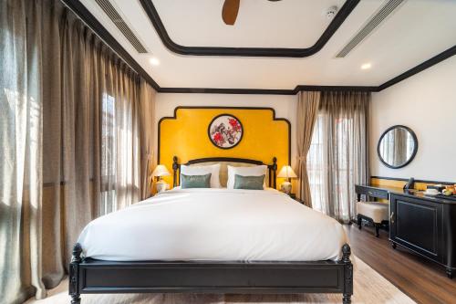 a bedroom with a large bed with a yellow headboard at Yzistel Hoi An in Hoi An