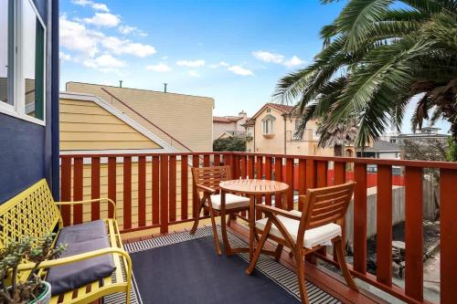 a patio with a table and chairs on a balcony at Ocean glimpse from the patio in Pacifica