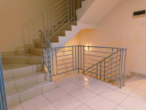 a staircase with a metal railing in a room at Senai three storey landed 14pax 5BR near airport in Kampung Seelung