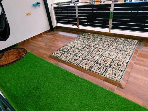 a green rug on a floor next to a balcony at Senai three storey landed 14pax 5BR near airport in Kampung Seelung