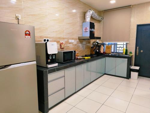 a kitchen with a refrigerator and a microwave at Senai three storey landed 14pax 5BR near airport in Kampung Seelung