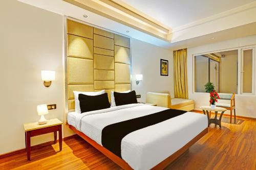 a hotel room with a large bed and a table at FabHotel Golden Vista in Bengaluru