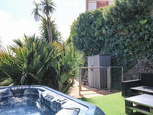 a swimming pool in a yard with a table and trees at Delmonte Lodge in Torquay