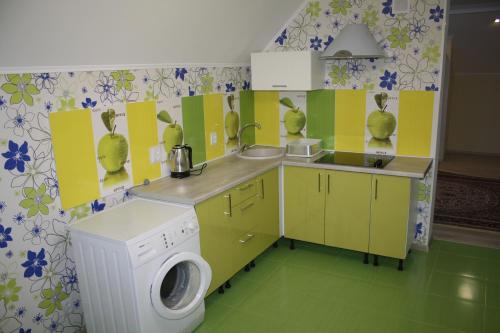una pequeña cocina con lavadora y lavadora en Apartments Galactika, en Uralsk