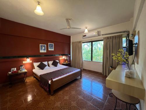 a hotel room with a bed and a television at Konkan Crown Resort & Club in Sawantwadi