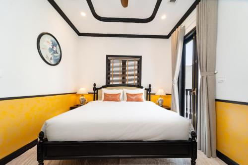 a bedroom with a bed and a window at Yzistel Hoi An in Hoi An