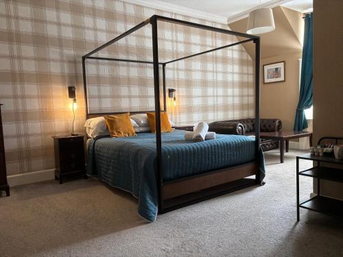 a bedroom with a four poster bed in a room at Ernespie House Hotel in Castle Douglas