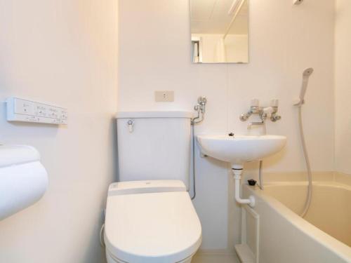 a small bathroom with a toilet and a sink at Tabist THE GREEN ASAHIKAWA in Asahikawa
