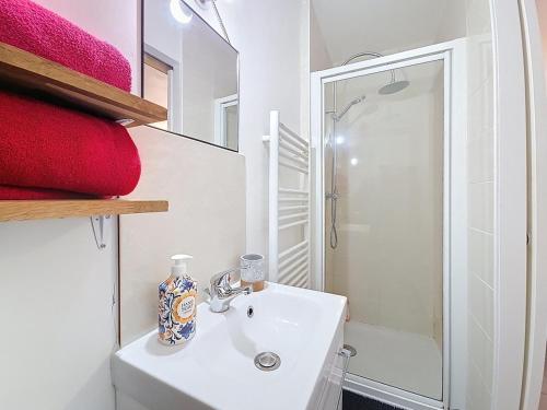 une salle de bain blanche avec un lavabo et une douche dans l'établissement studio 15 minutes from Disney, Paris, à Le Pin