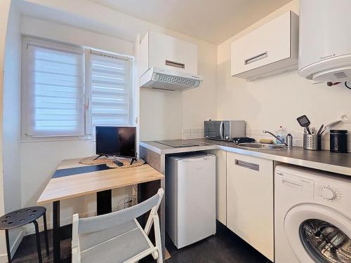 Elle comprend une petite cuisine avec un bureau et un ordinateur portable. dans l'établissement studio 15 minutes from Disney, Paris, à Le Pin