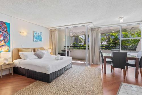 a bedroom with a bed and a dining room at Hi Ho Beach Apartments on Broadbeach in Gold Coast