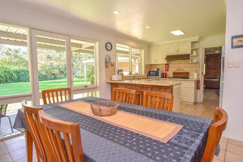 a kitchen with a table and chairs and a kitchen with a counter at Ovens Valley Retreat in Myrtleford