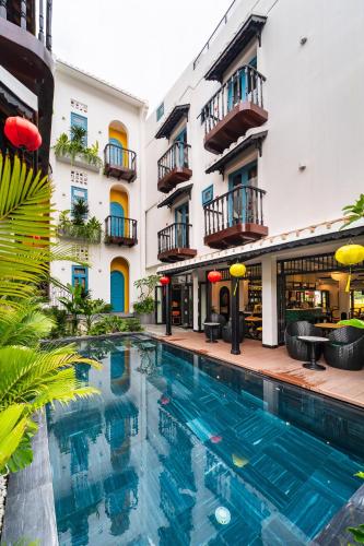a swimming pool in front of a building at Yzistel Hoi An in Hoi An