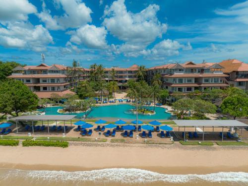 an aerial view of a resort with a pool and chairs and umbrellas at Hotel Nikko Bali Benoa Beach in Nusa Dua