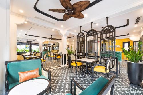 a restaurant with chairs and tables and a ceiling fan at Yzistel Hoi An in Hoi An