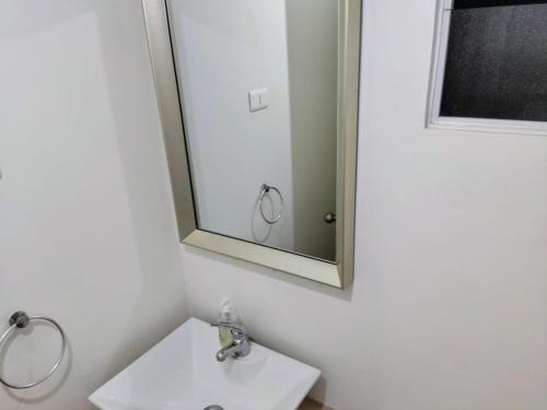 un bagno con lavandino e specchio di Depto-House Patio Privado Frente al Mar en Condominio Las Cruces a Las Cruces