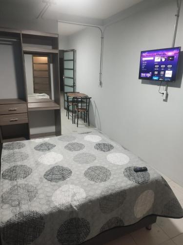 a bedroom with a bed with a tv on the wall at Loft en el corazón de Orizaba in Orizaba