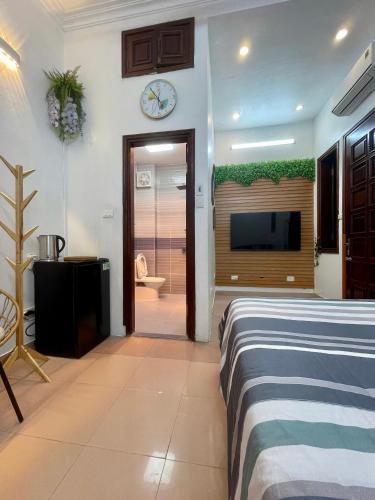 a bedroom with a bed and a flat screen tv at Bamboo Homestay Old Quarter in Hanoi