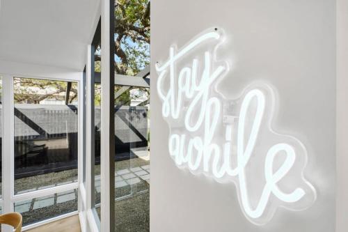 マリブにあるMalibu Beach House by Stay Awhile Villasの世界への喜びの言葉を持つ扉の看板