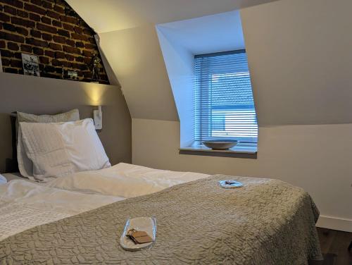 a bedroom with a bed and a window at Mijn appartement met sauna en lift in Voerendaal