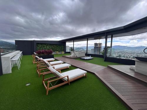 a deck with lounge chairs and tables on a building at Apartamento en Barrio Escalante in San José