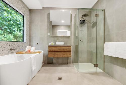 a bathroom with a glass shower and a sink at Belle Escapes Bluewater Breeze in Trinity Beach