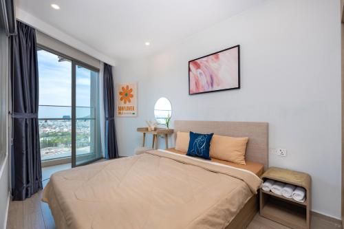 a bedroom with a large bed and a large window at The Sóng Luxury Apartment Vung Tau - Tuấn Hoà Homestay in Vung Tau