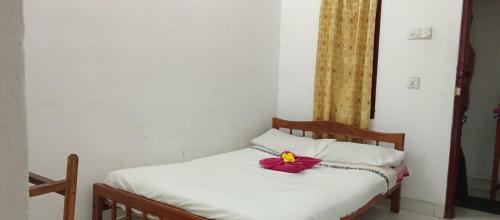 a bed with a red flower sitting on top of it at Akshaya Rest Maskeliya in Nikawatawana